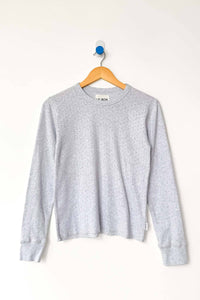 Gray long sleeve top on a wooden hanger against a white background