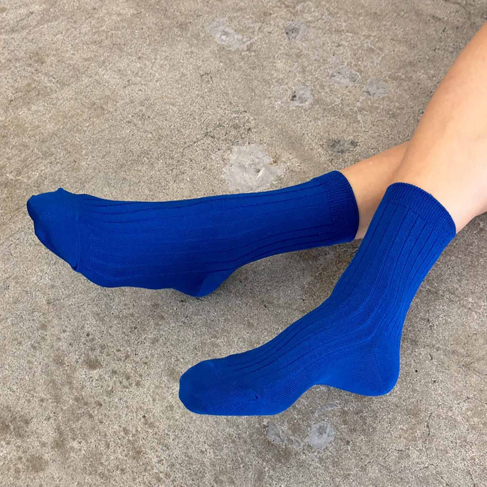 
                  
                    A person wears cobalt blue ribbed crew socks
                  
                