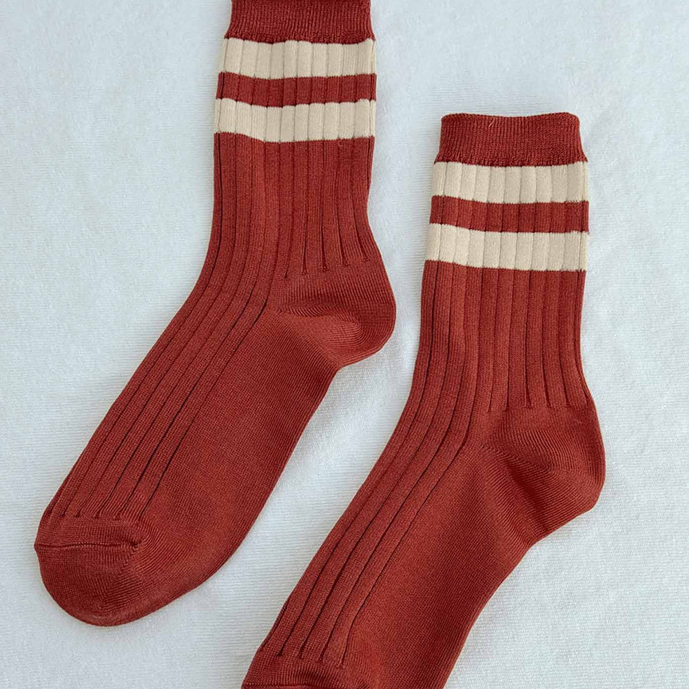 A flat view of a pair of red and cream striped crew socks