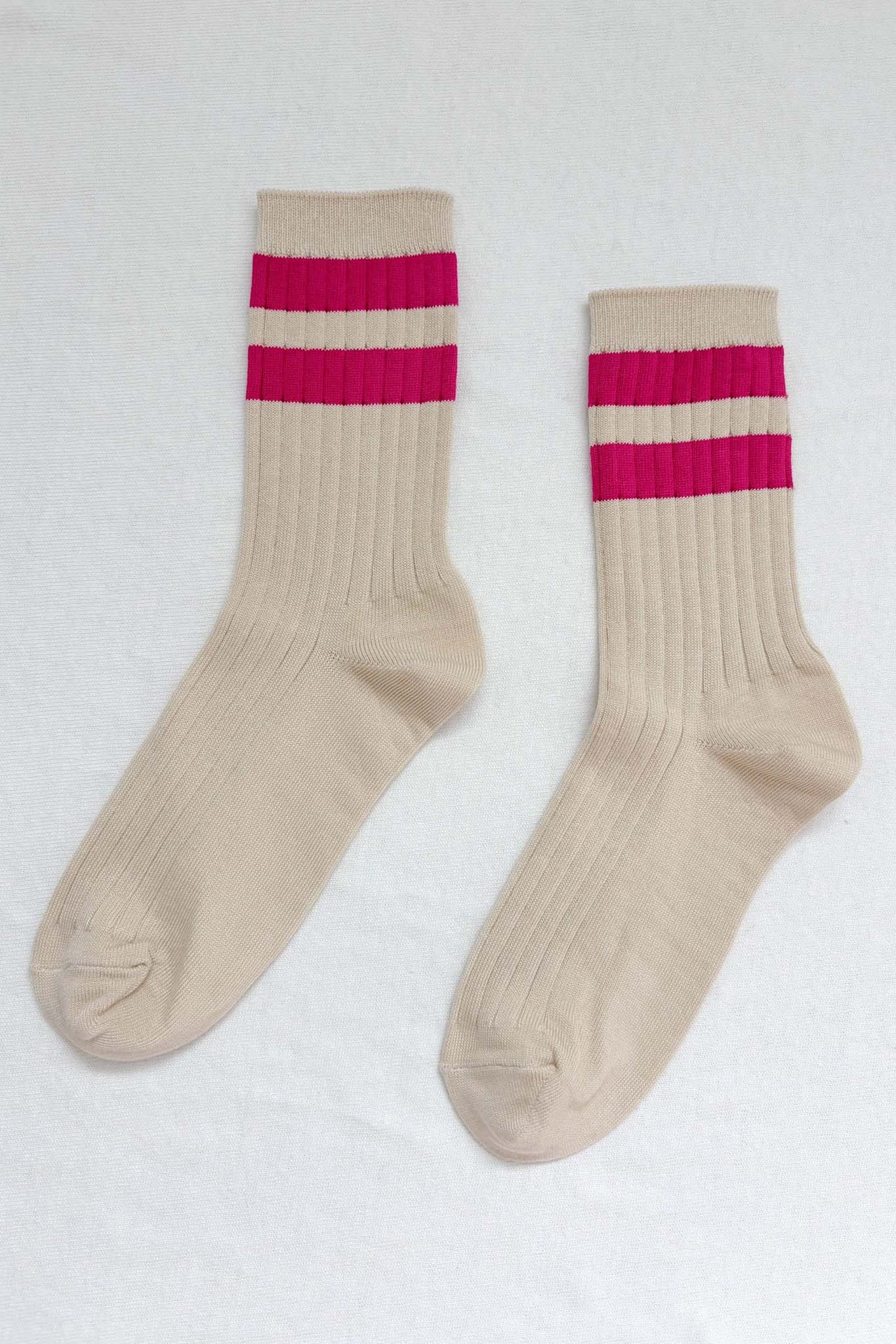 Pair of beige socks with pink stripes on a white background