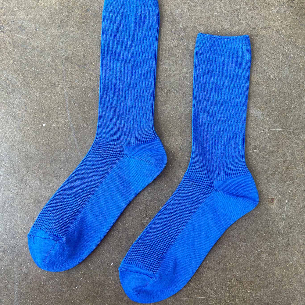 Pair of blue socks on a gray concrete surface