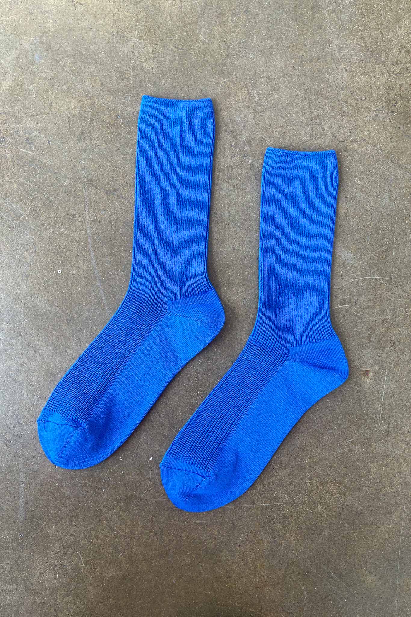 Pair of blue socks on a gray concrete surface