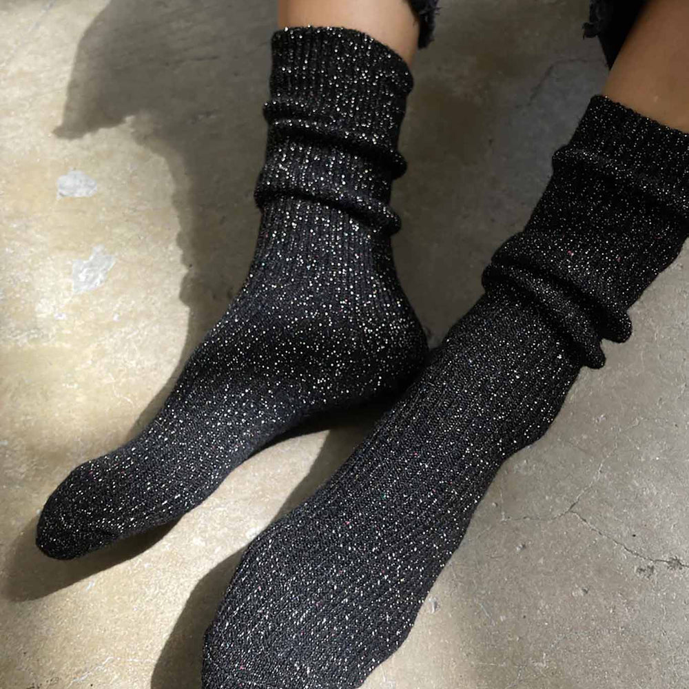 
                  
                    A person wearing black glitter ribbed crew socks
                  
                