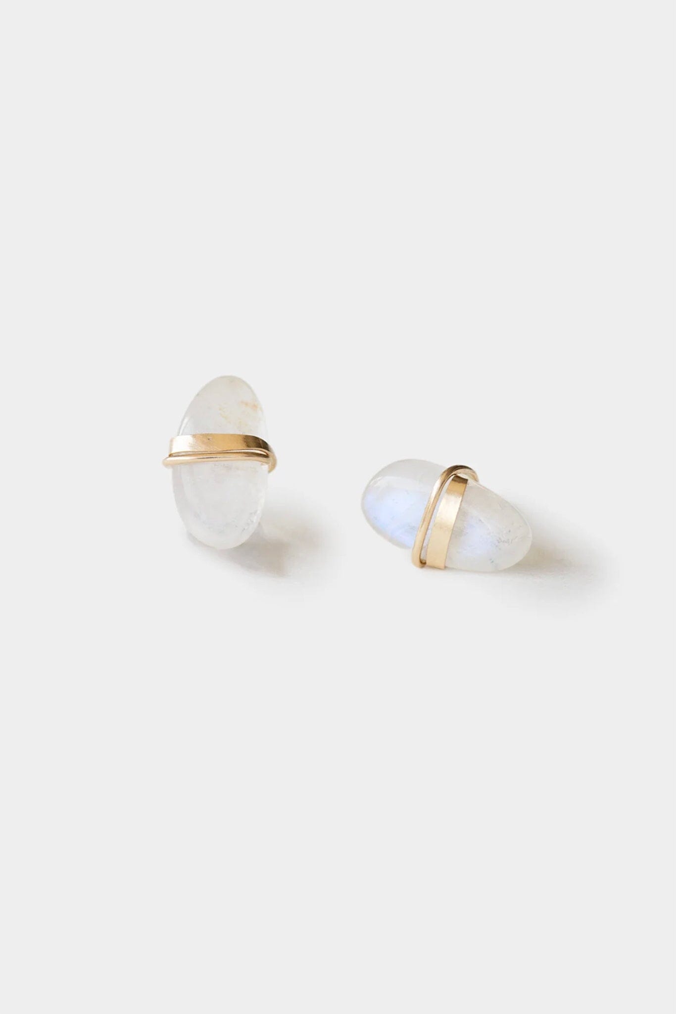 Pair of earrings with gold and white stone design on a light background