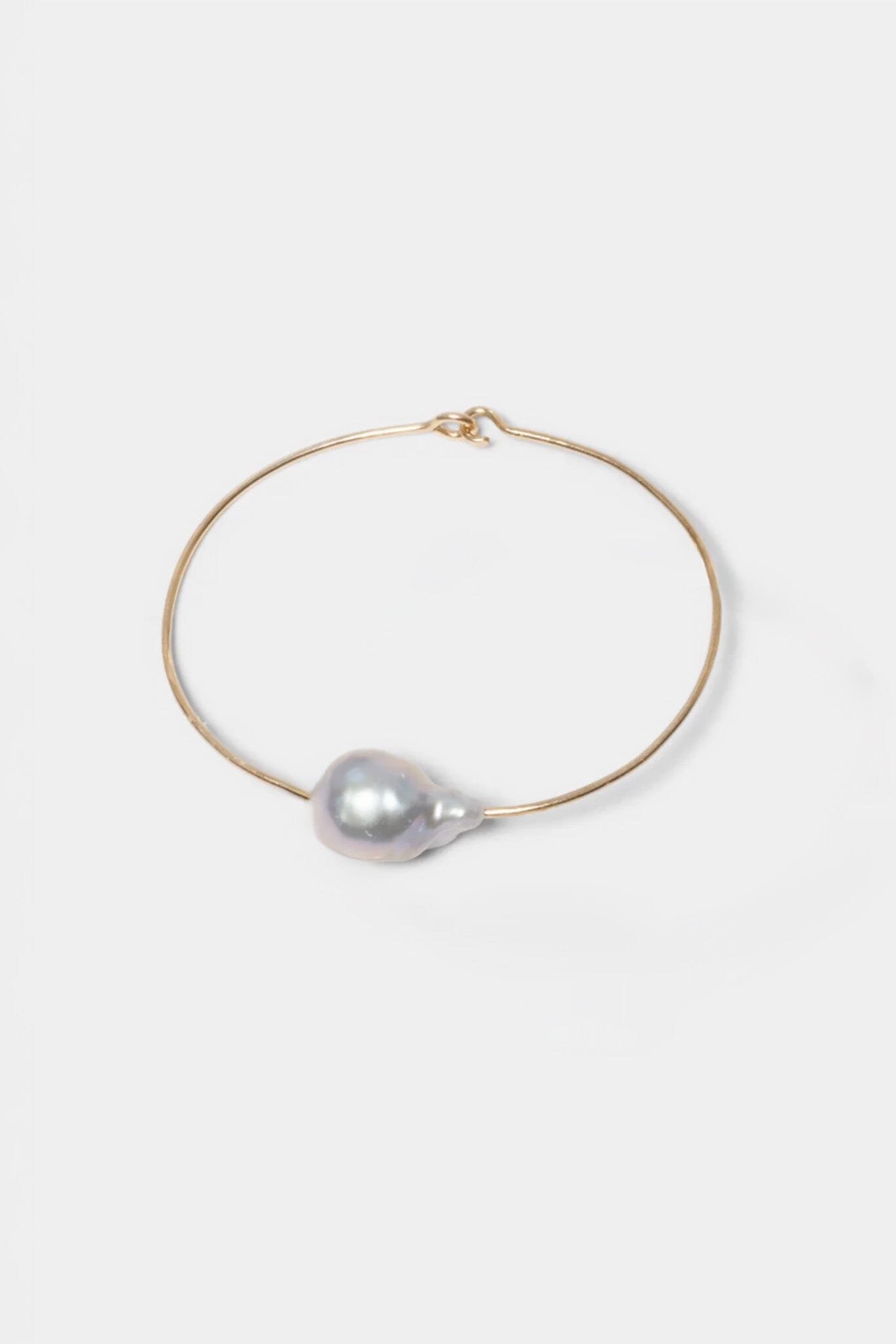 a silver baroque pearl on a gold filled wire bracelet