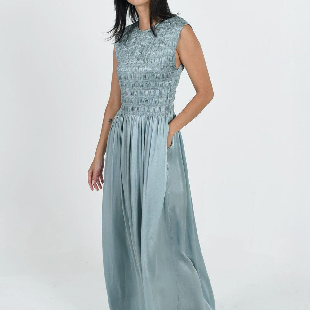 The Aliya Dress by M.Patmos is a chic women's dress made from 100% silk satin, featuring a flattering silhouette and vibrant tourmaline color.