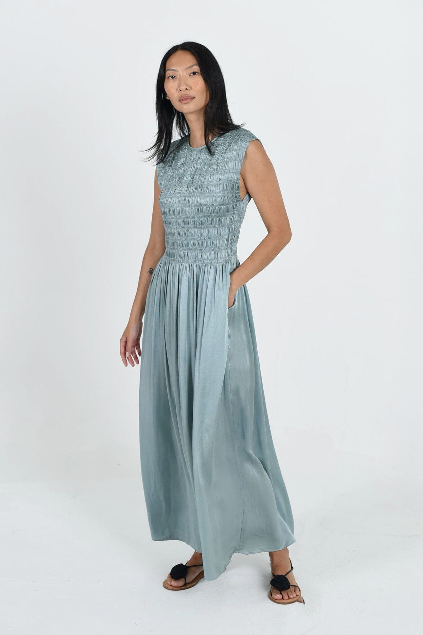 The Aliya Dress by M.Patmos is a chic women's dress made from 100% silk satin, featuring a flattering silhouette and vibrant tourmaline color.