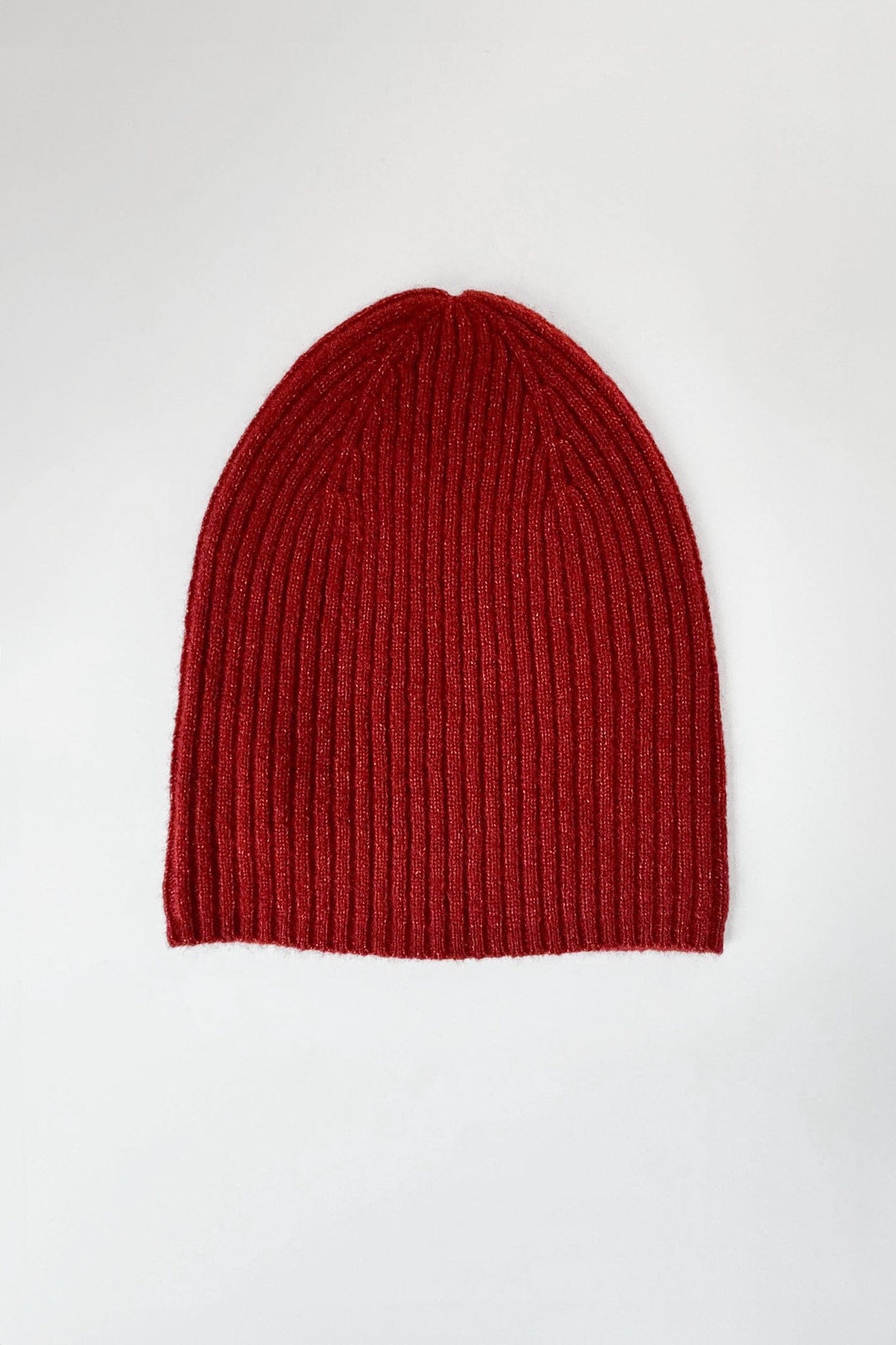 A red, ribbed beanie hat made of cashmere, displayed against a white background.