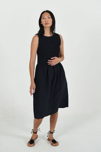 Woman wearing a black sleeveless dress on a white background