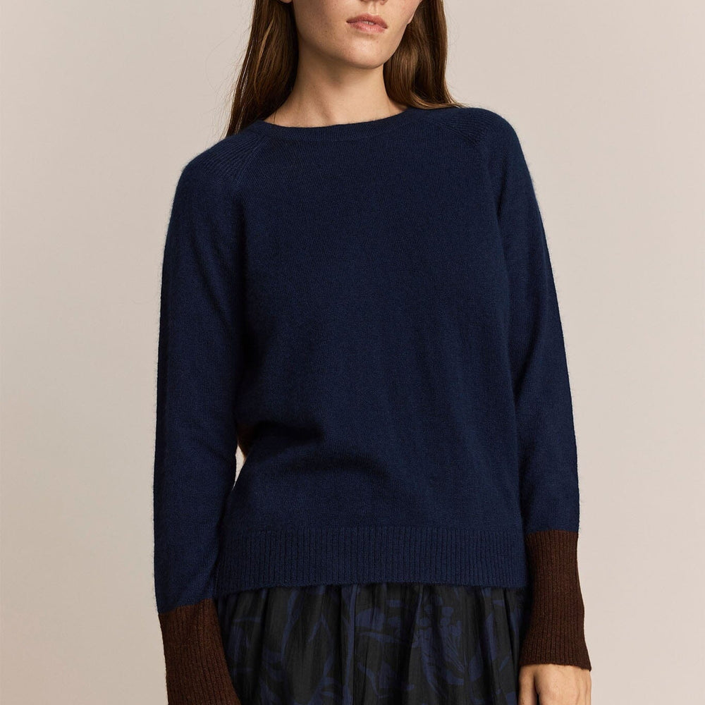 
                  
                    A woman wearing a navy and maroon long sleeve cashmere and wool sweater
                  
                