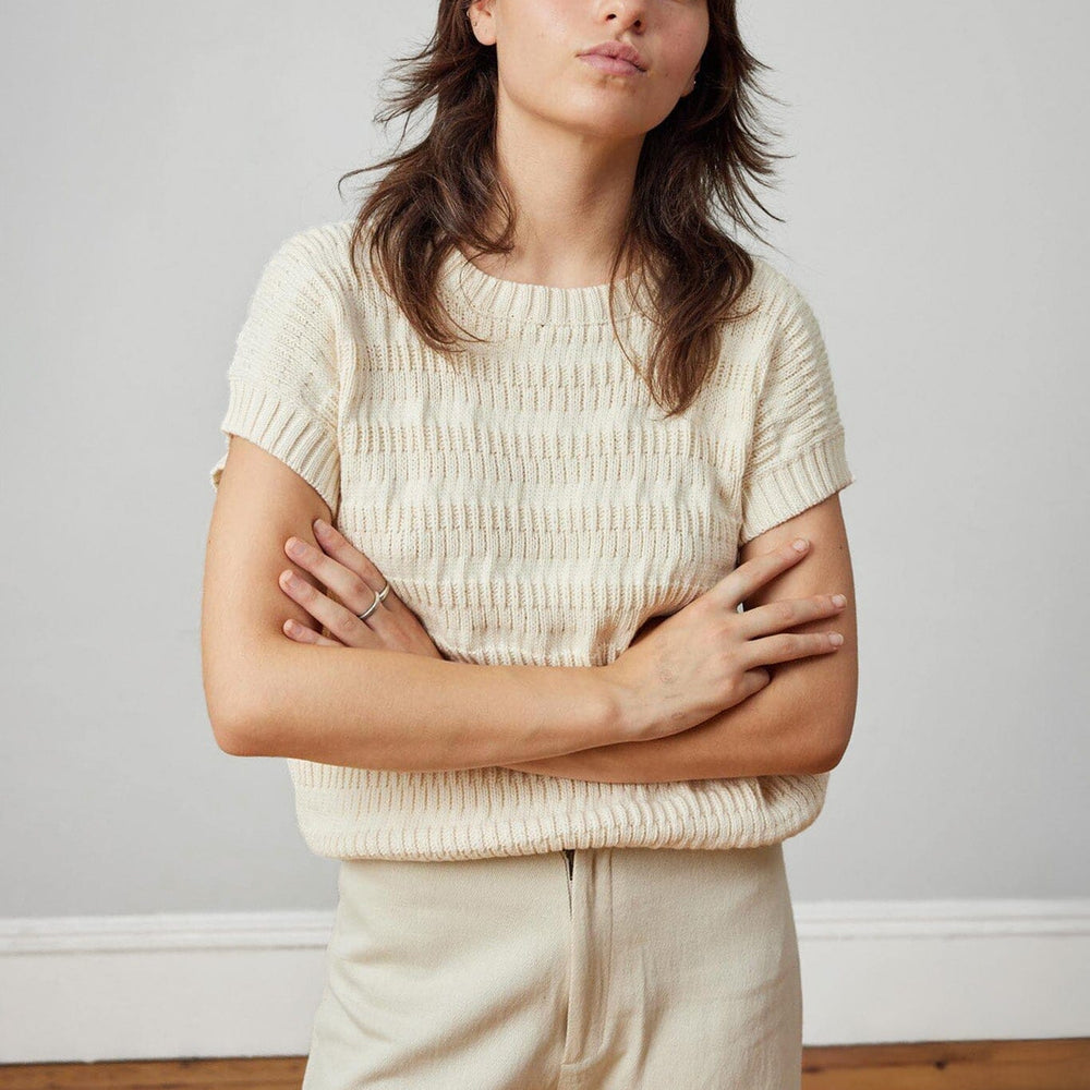 A lightweight, cream, knit short sleeve womens top. Made in Peru.