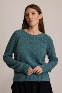 Woman wearing the M.PATMOS Corinne Pullover in Mineral, a merino cashmere raglan sweater with v-eyelet yoke.