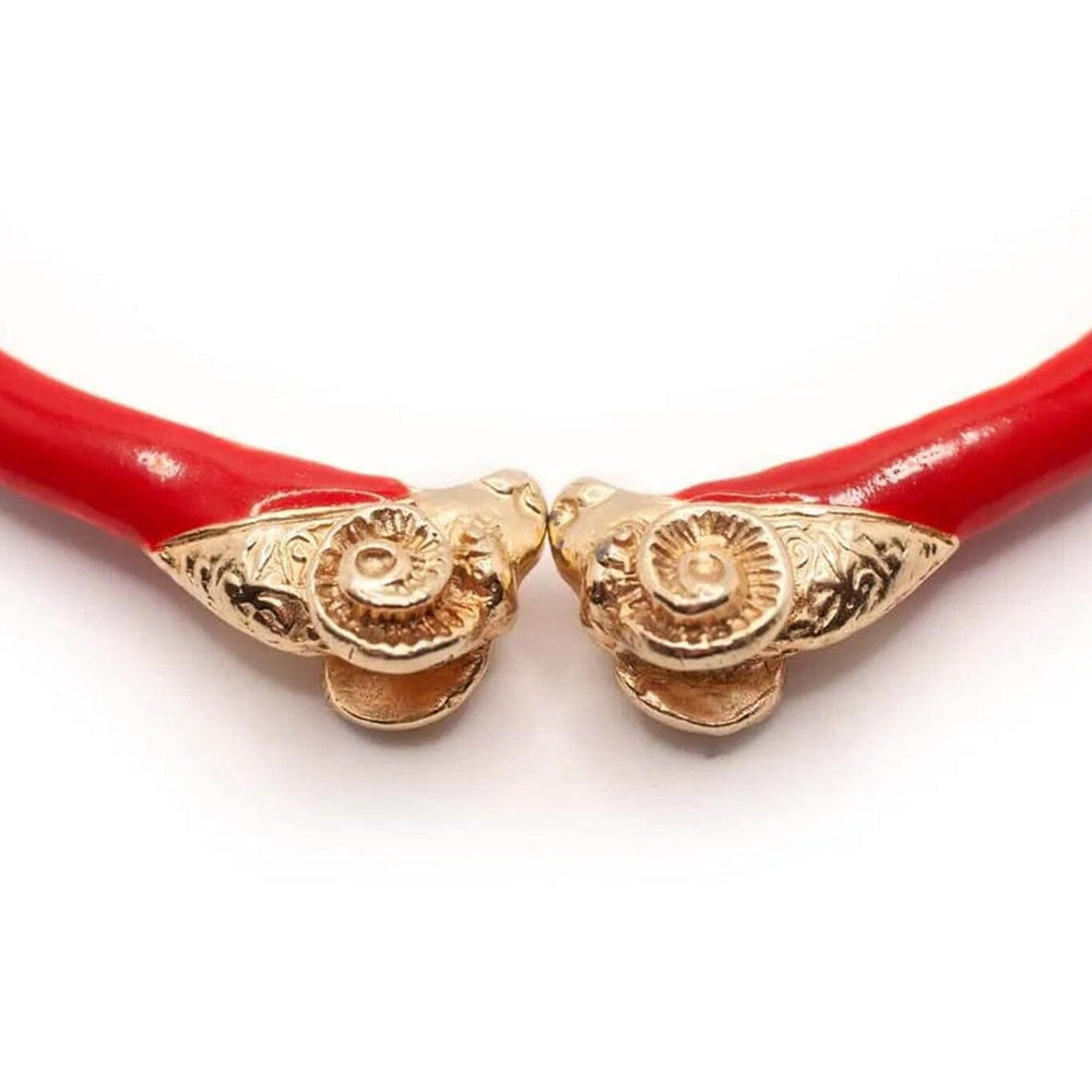 
                  
                    Red enamel rams head choker necklace with gold clasp on a white background
                  
                
