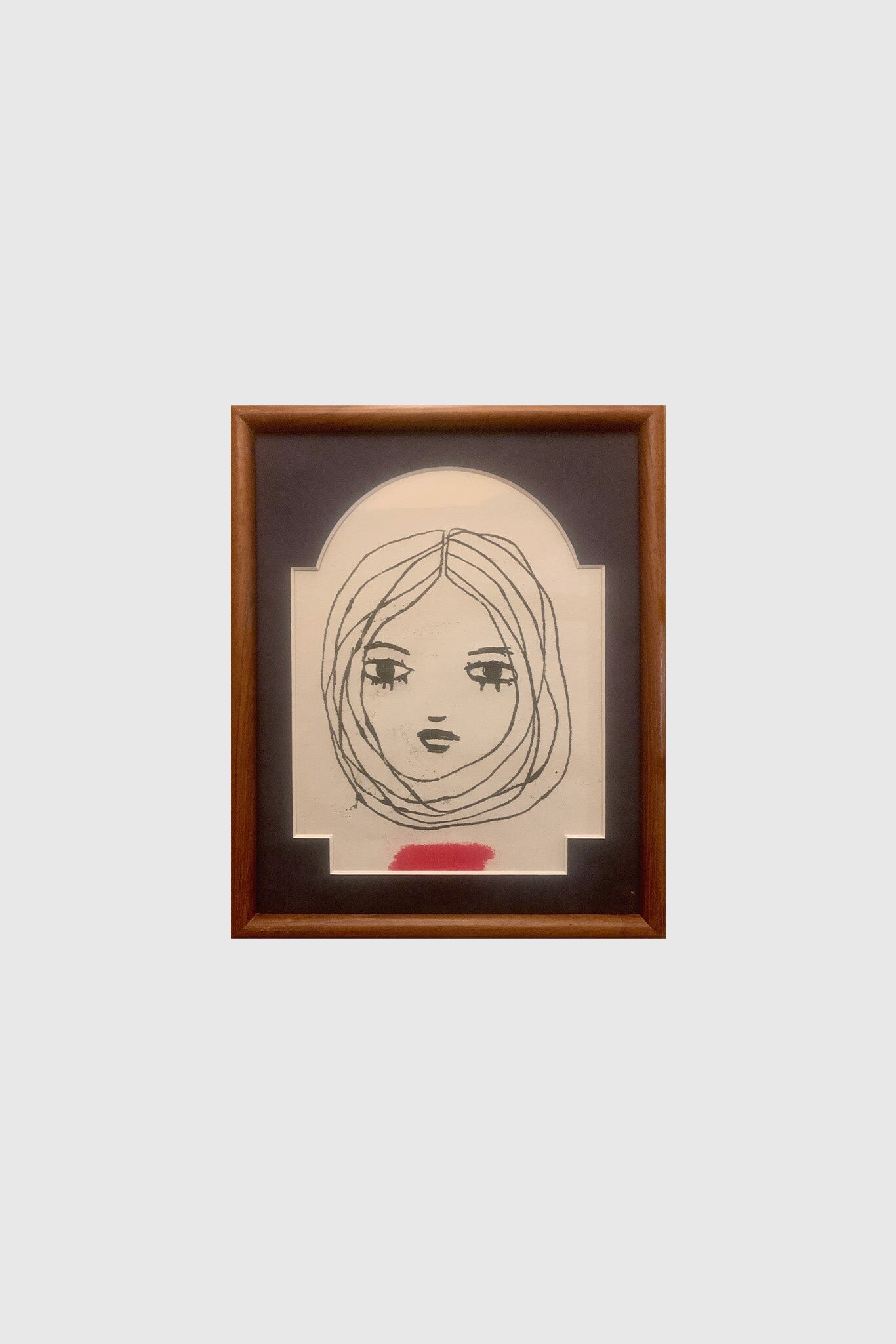 Small illustration of a woman's face in an rectangular frame.