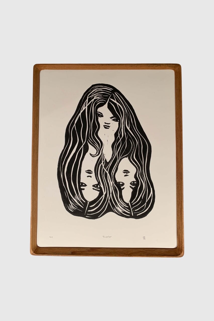 Black and white linoprint artwork featuring three connected women's faces and hair.