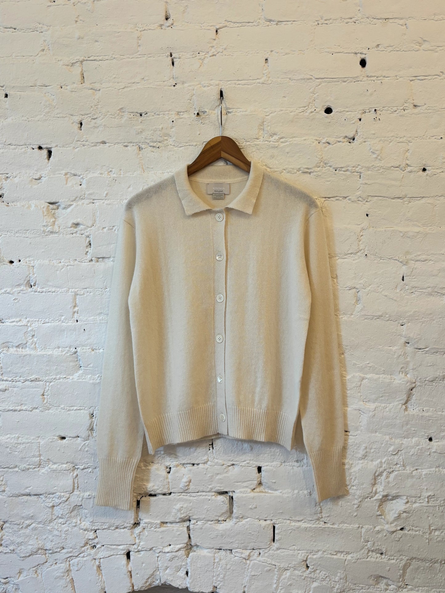 Ivory collared button-front knit cardigan with long sleeves and ribbed cuffs and hem