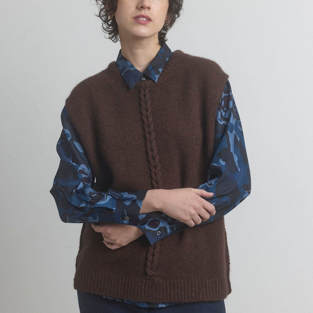 
                  
                    Woman wearing a merino brown sweater vest on a plain background.
                  
                