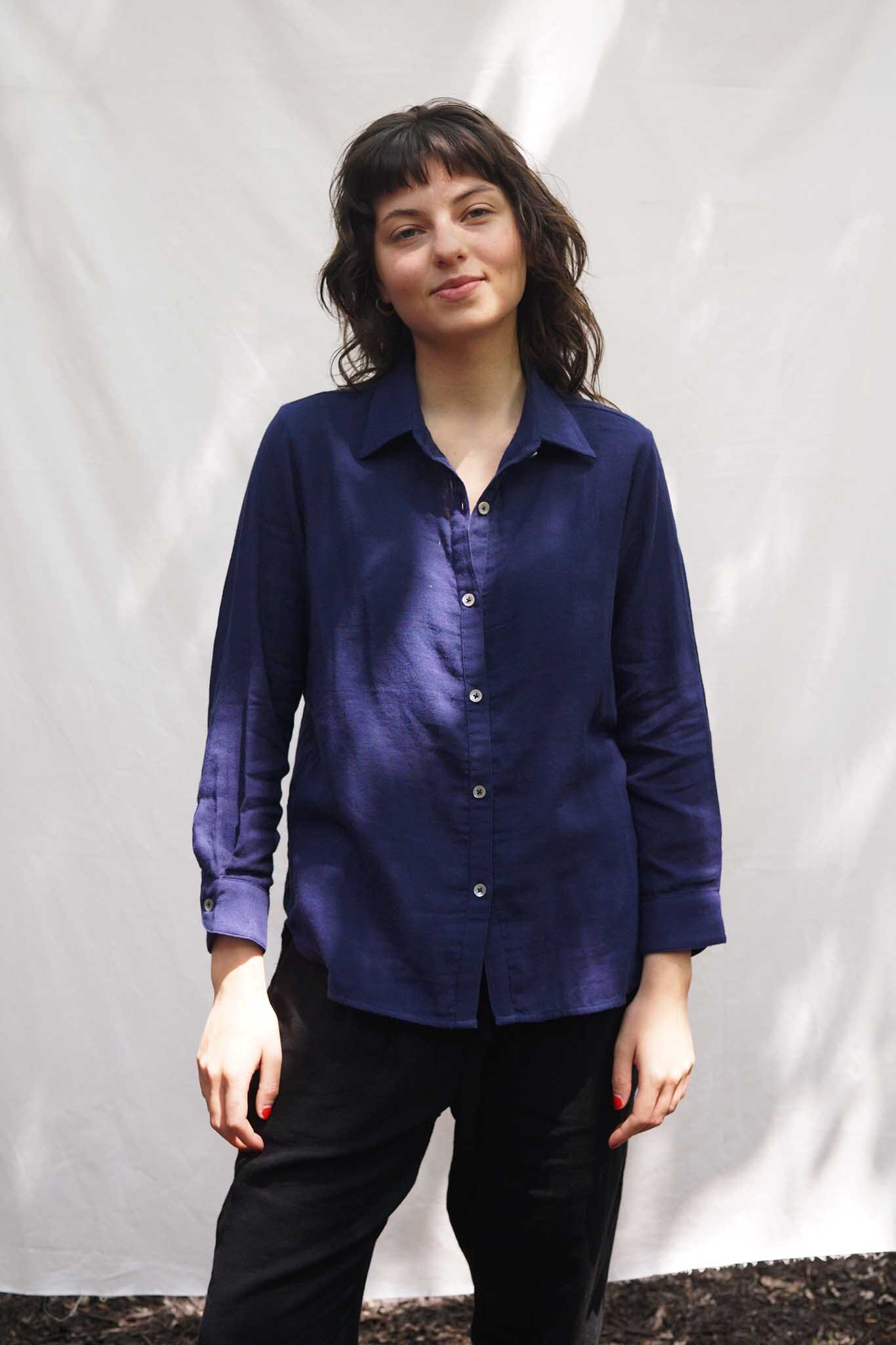 A woman wears the M.Patmos navy Leroy shirt in 100% cotton. The shirt is a lightweight button down with a collar and long sleeves.