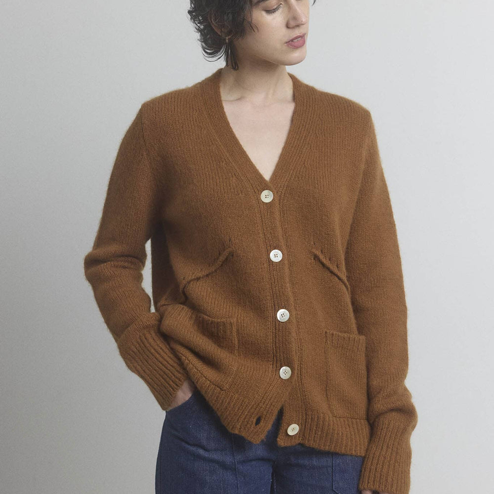 Woman wearing a brown wool and cashmere blend cardigan with a plain background