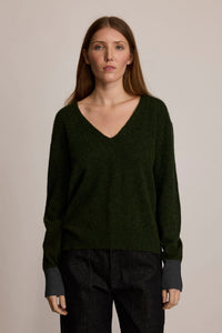 Woman wearing the M.PATMOS Lily Pullover in Forest Combo, a relaxed green v-neck cashmere silk sweater.