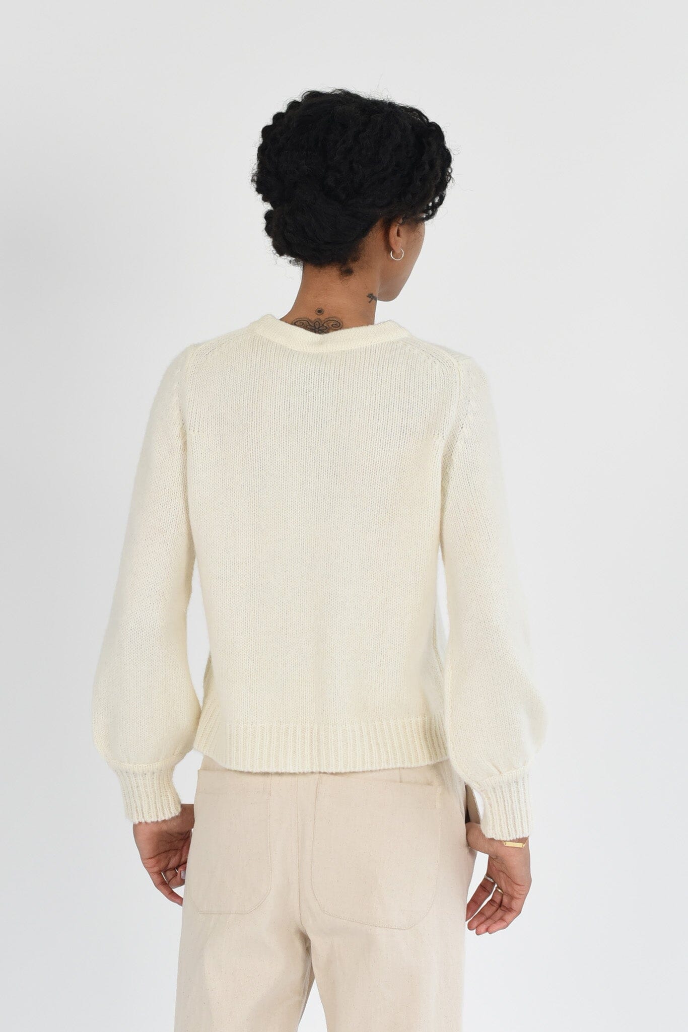 Woman wearing a white knit long sleeve sweater