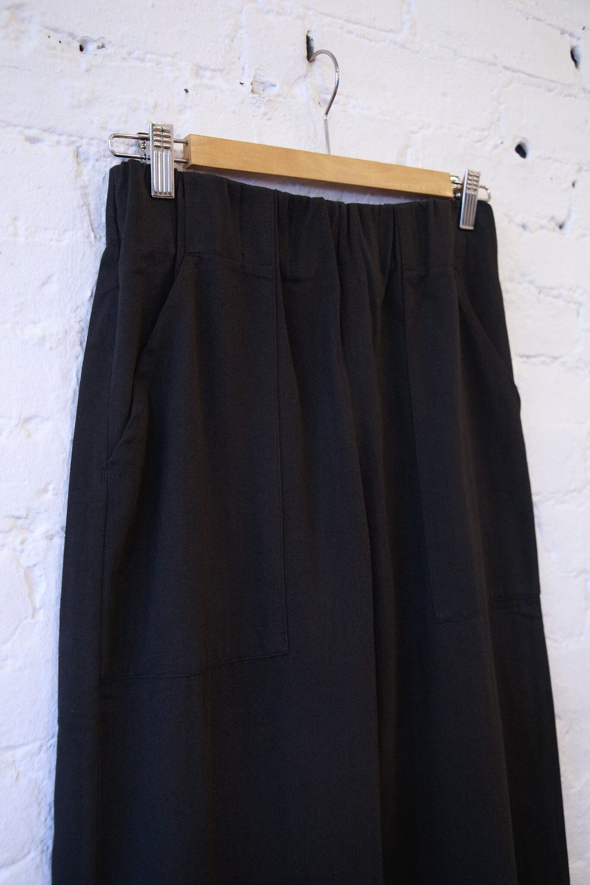 Woman wearing the M.PATMOS Marco Pant in Black, a modern elastic waistband wide leg trouser with surplus pockets.