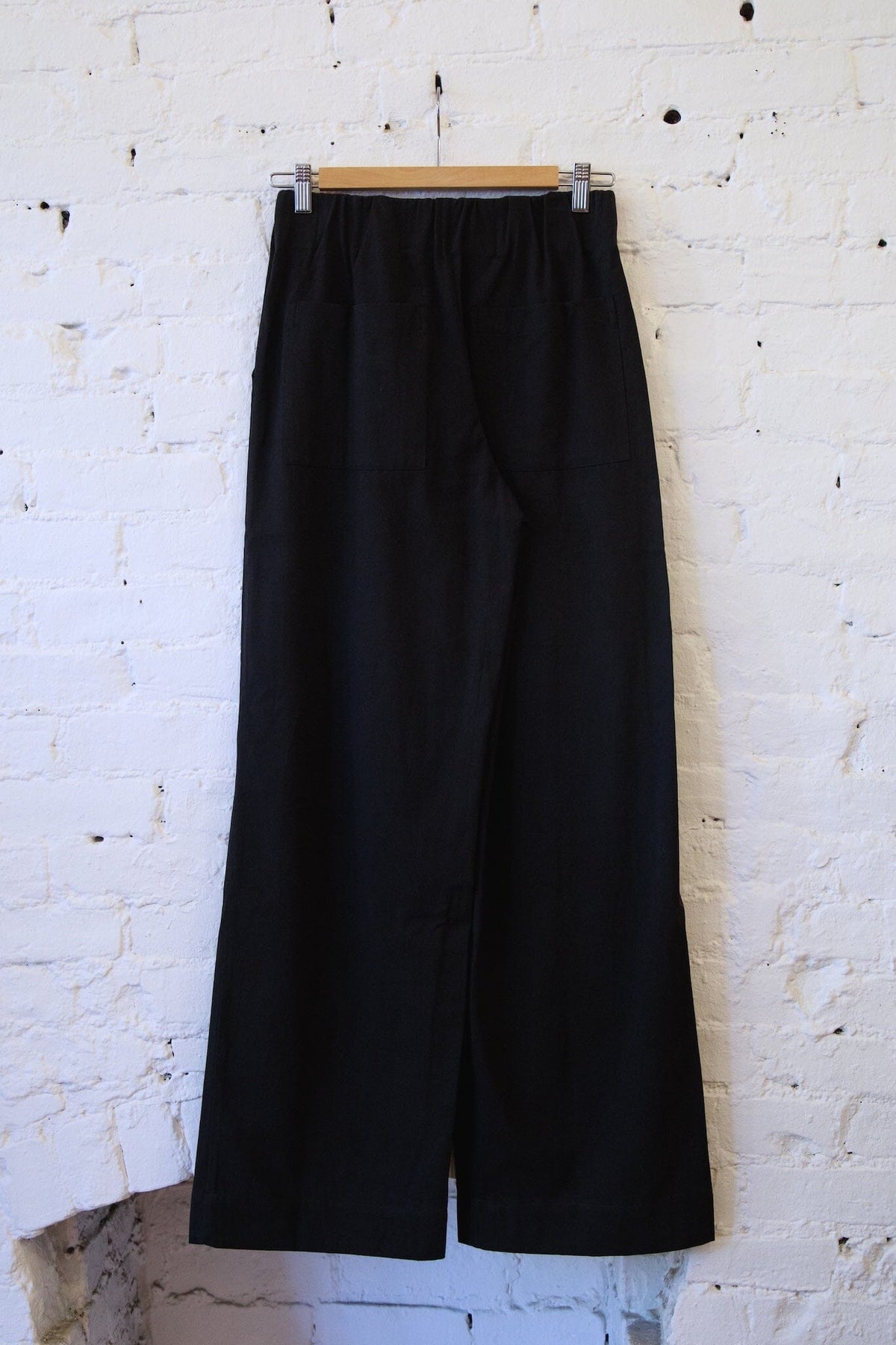 Woman wearing the M.PATMOS Marco Pant in Black, a modern elastic waistband wide leg trouser with surplus pockets.