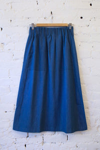 Woman modeling the M.PATMOS Nash Skirt in Chambray, a paneled wool skirt with an elastic waistband and pockets.