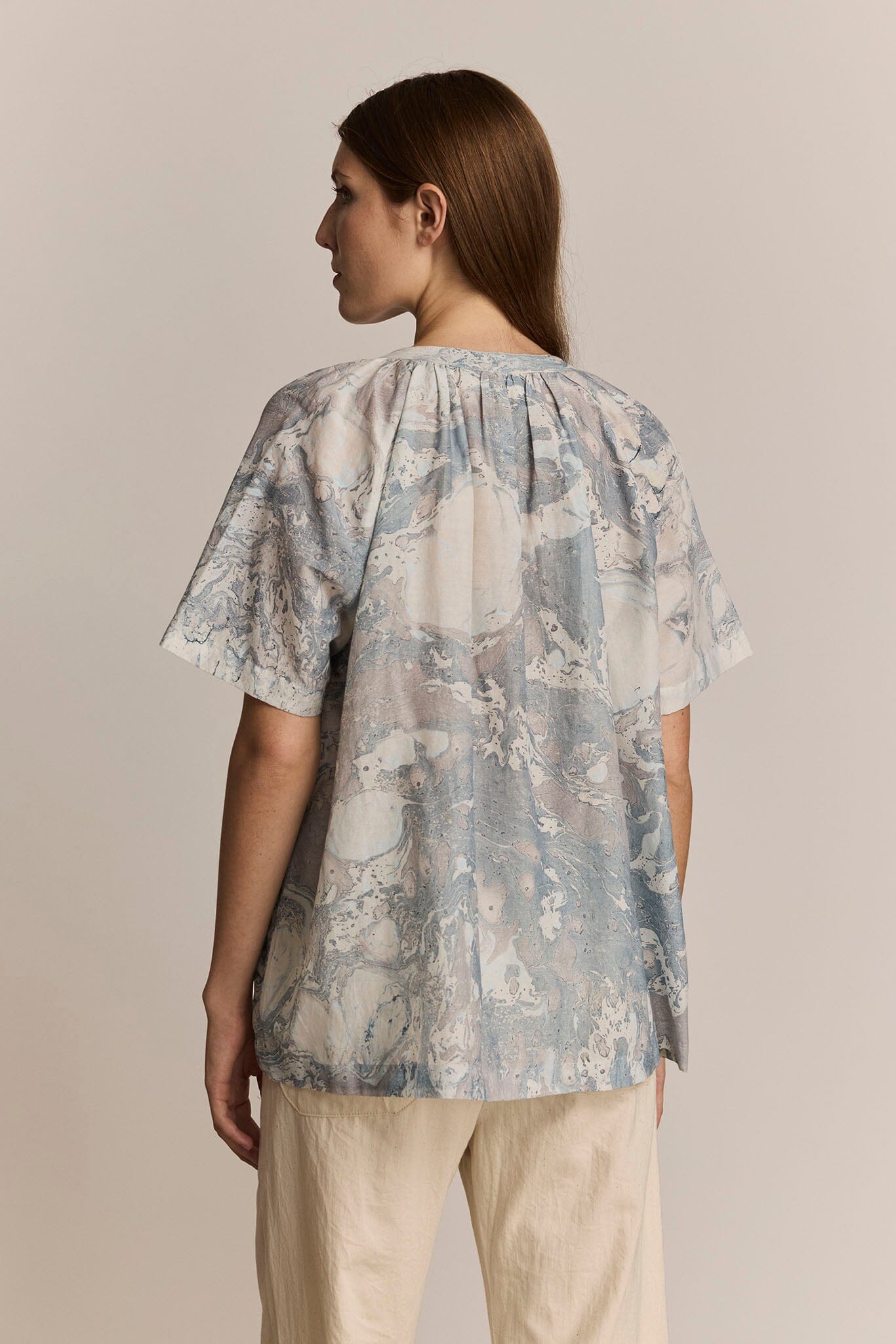 Woman wearing a floral blouse with a neutral background