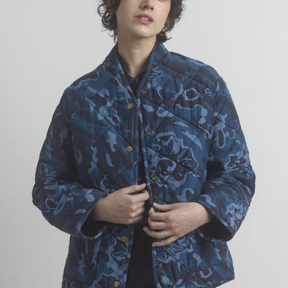 Person wearing a cotton and silk blue patterned jacket against a plain background