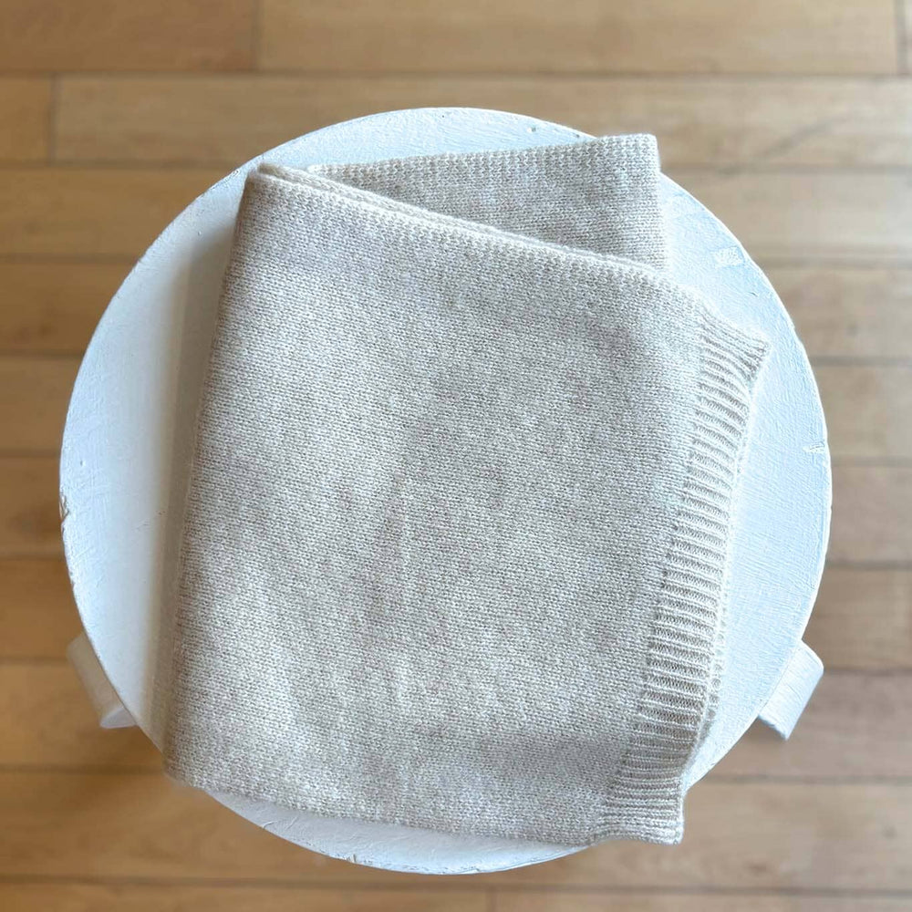 
                  
                    Folded beige fabric on a white plate against a wooden background
                  
                