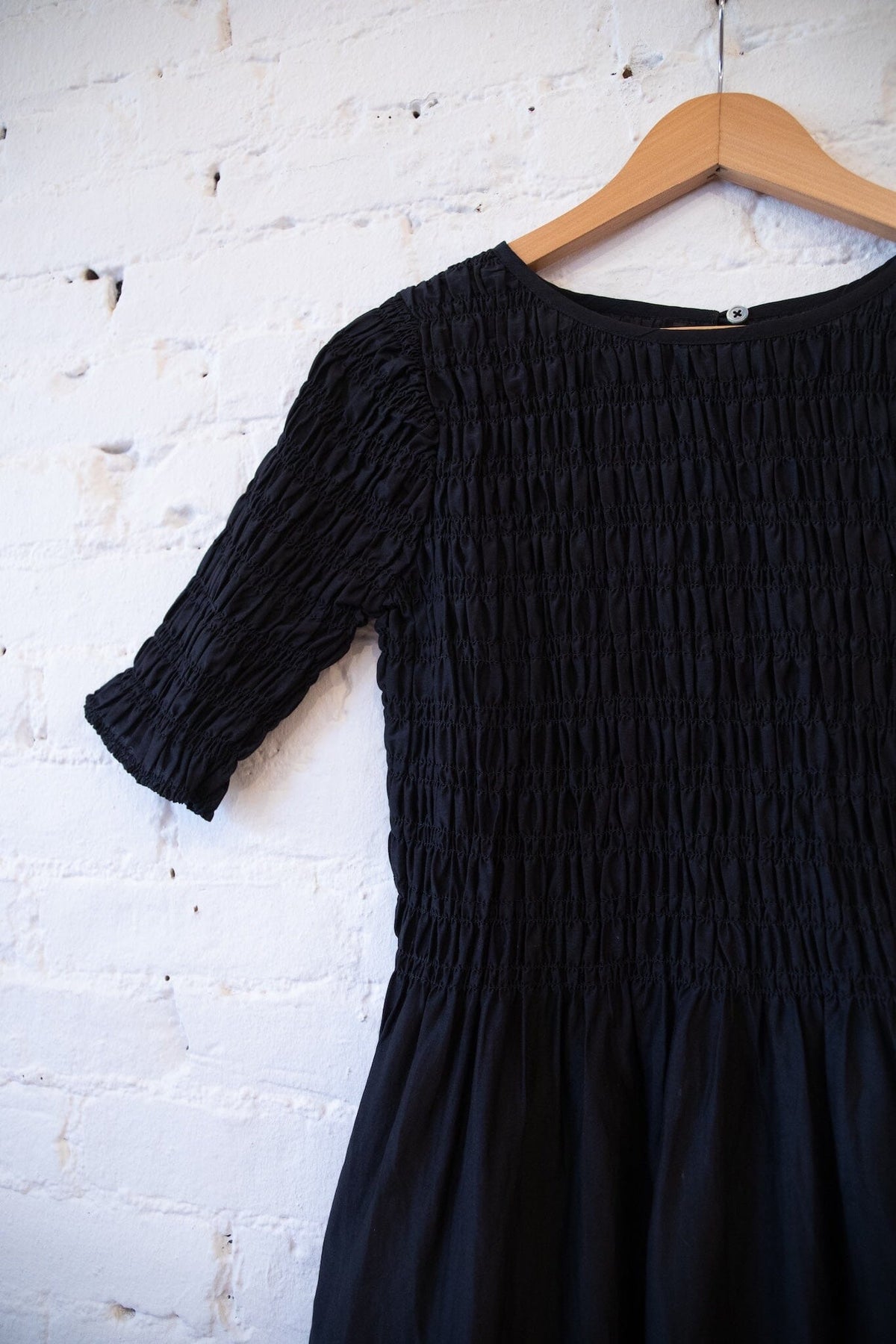 M.PATMOS Sasha Smocked Dress in Black, a midi dress with side pockets.