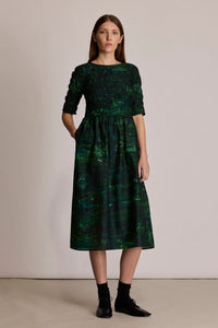 M.PATMOS Sasha Smocked Dress in Park Flora, a green custom print midi dress with side pockets.