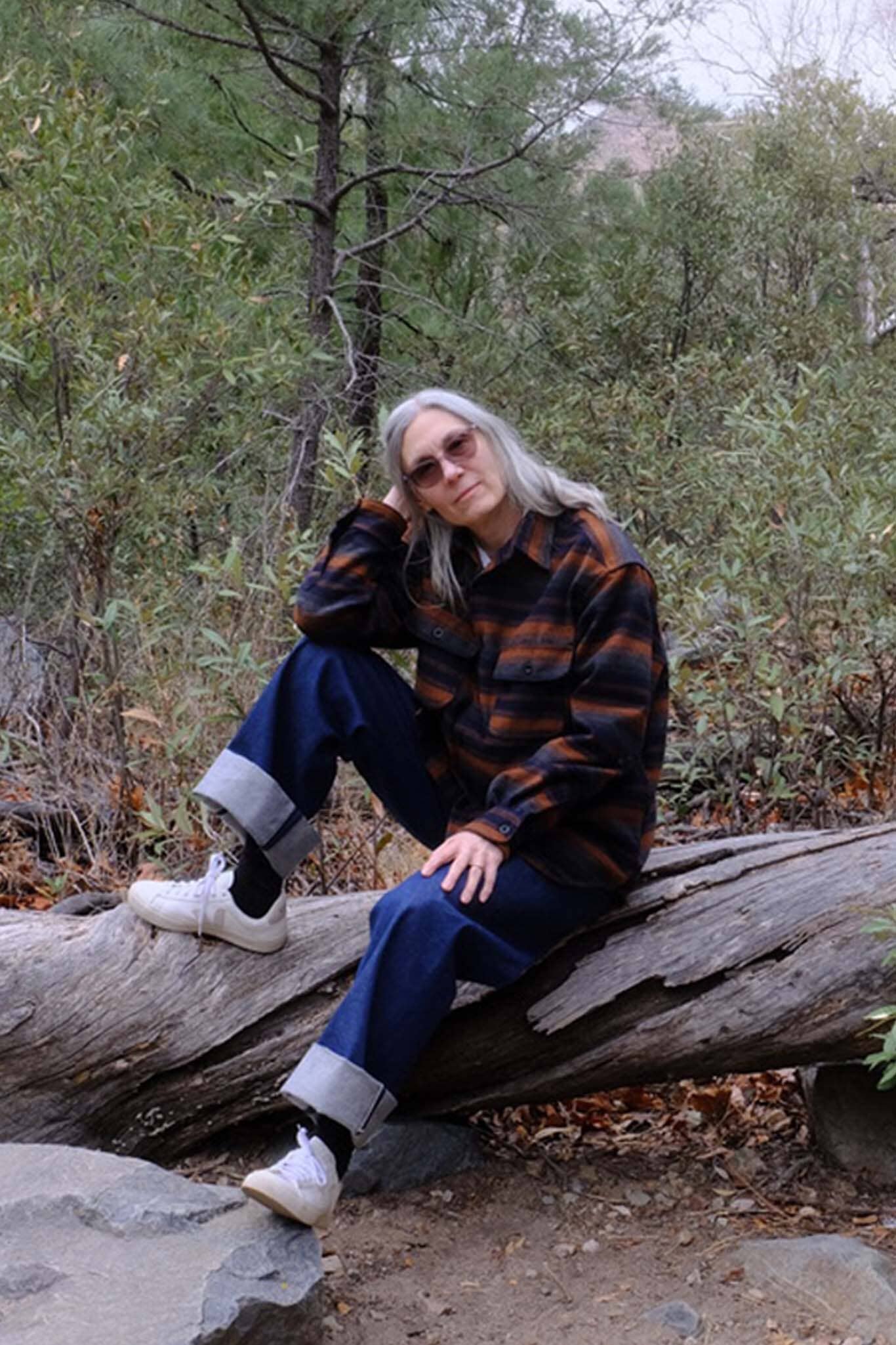 Woman sitting wearing the UQNATU denim selvage sailor pants
