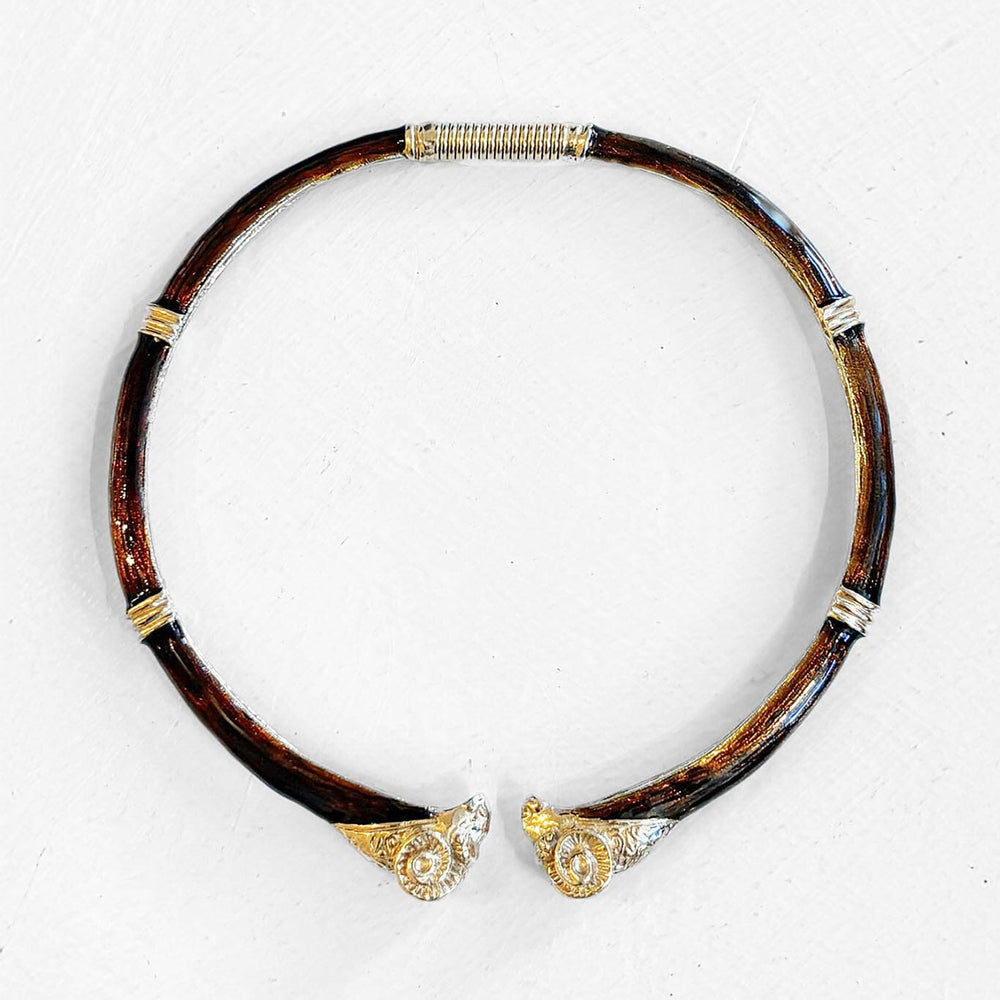 Decorative dark brown vintage enamel necklace with gold accents and rams heads on a white background