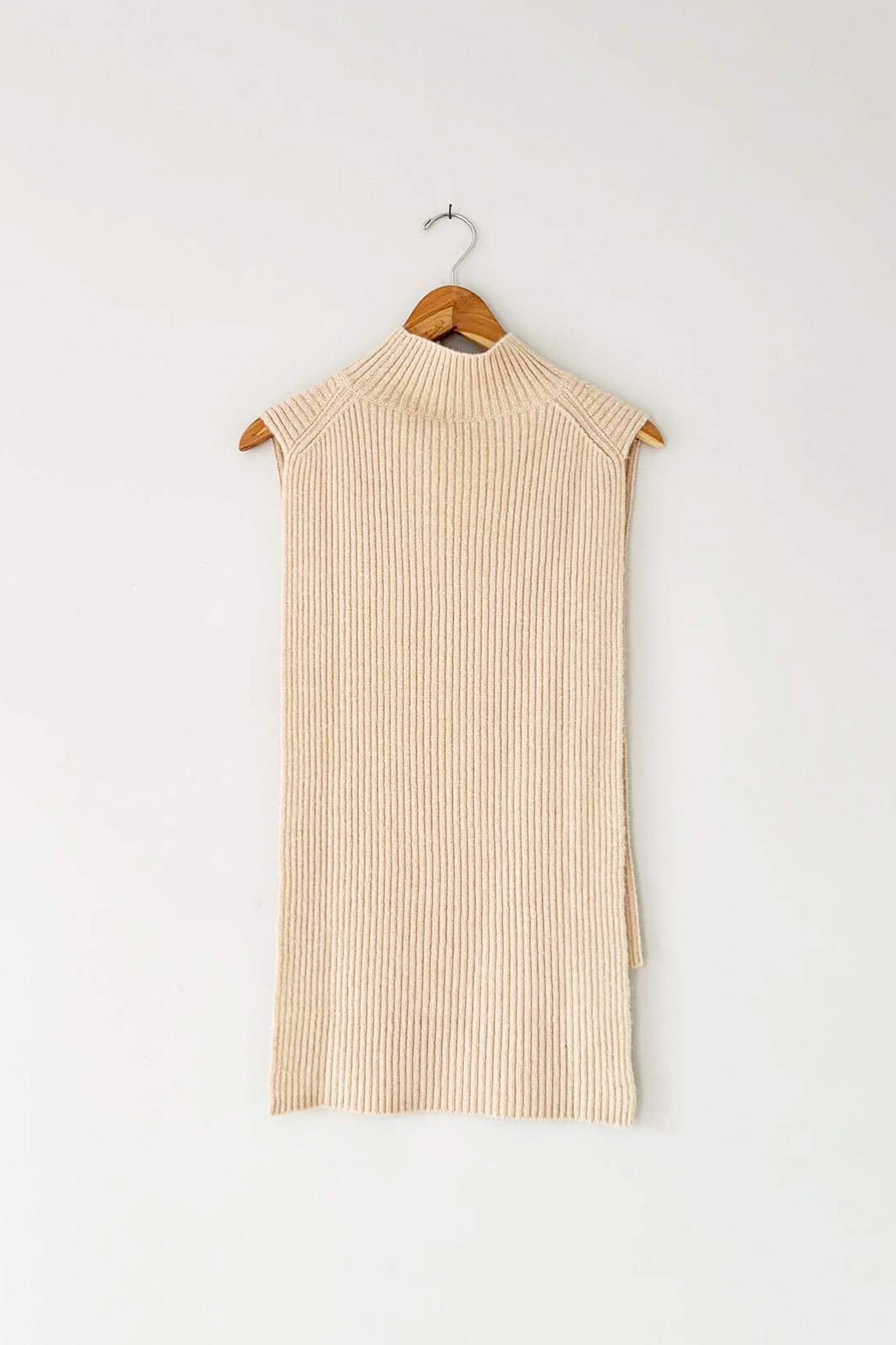 A beige, ribbed wool and cashmere blend vest with a mock funnel neck and high low hemline, displayed on a wooden hanger.