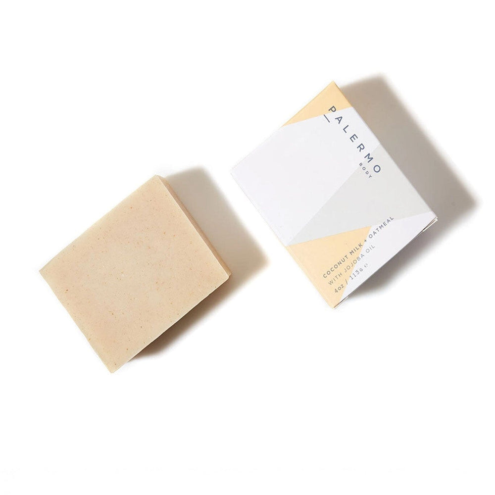 A beige bar of soap with a cardboard packaging that has 'Palermo Body' written on it, placed on a white background.