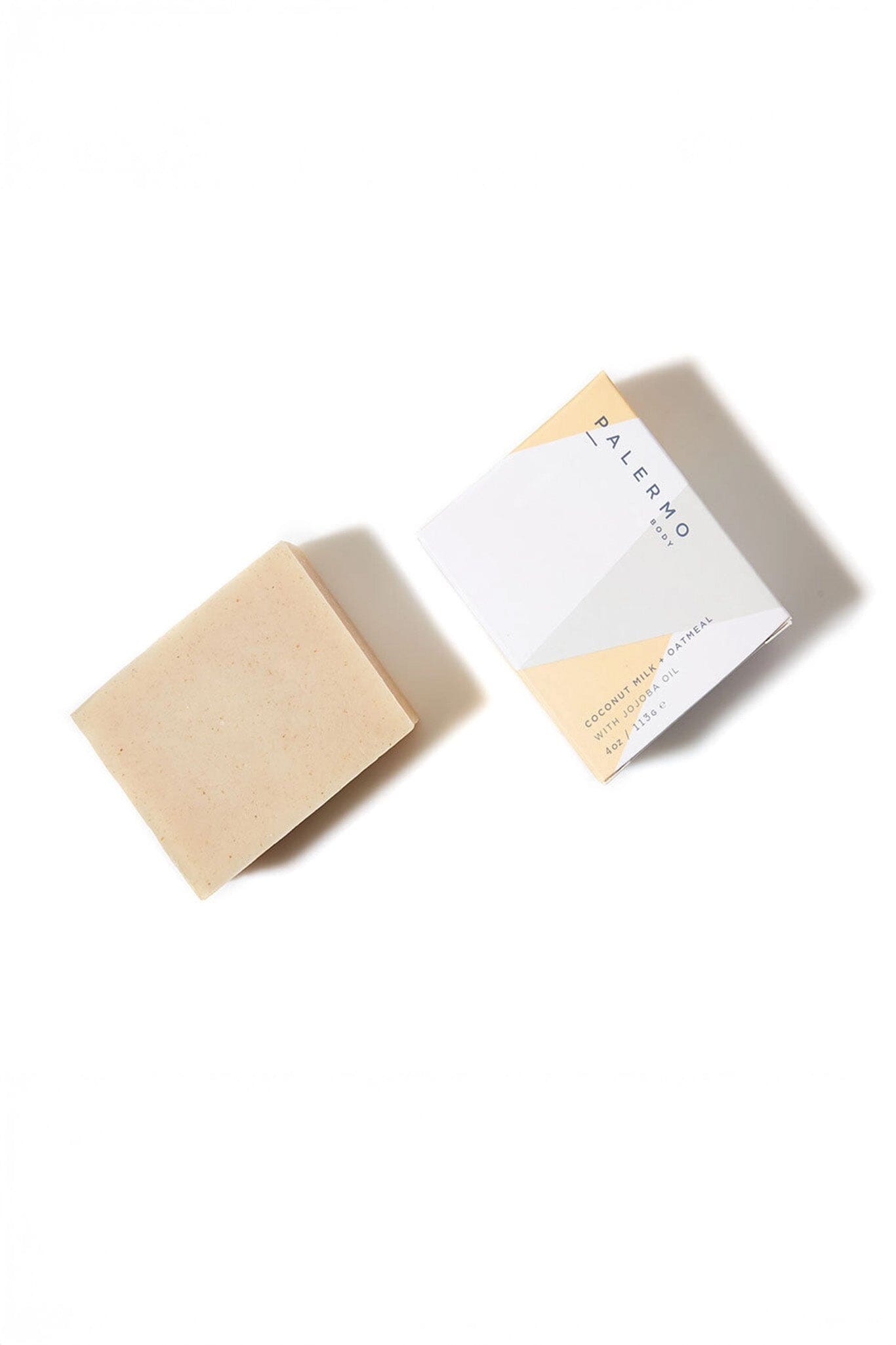 A beige bar of soap with a cardboard packaging that has 'Palermo Body' written on it, placed on a white background.