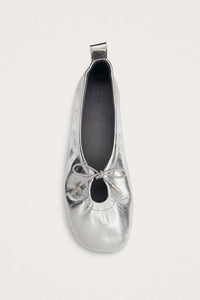 Silver metallic ballerina shoe with a top tie on a white background