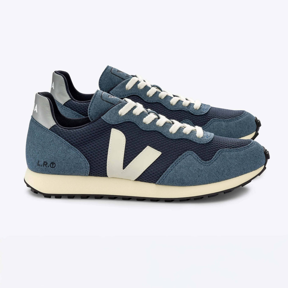 The side view of a pair of blue and white Veja SDU Alveomesh sneakers with mesh paneling and a lace-up closure.