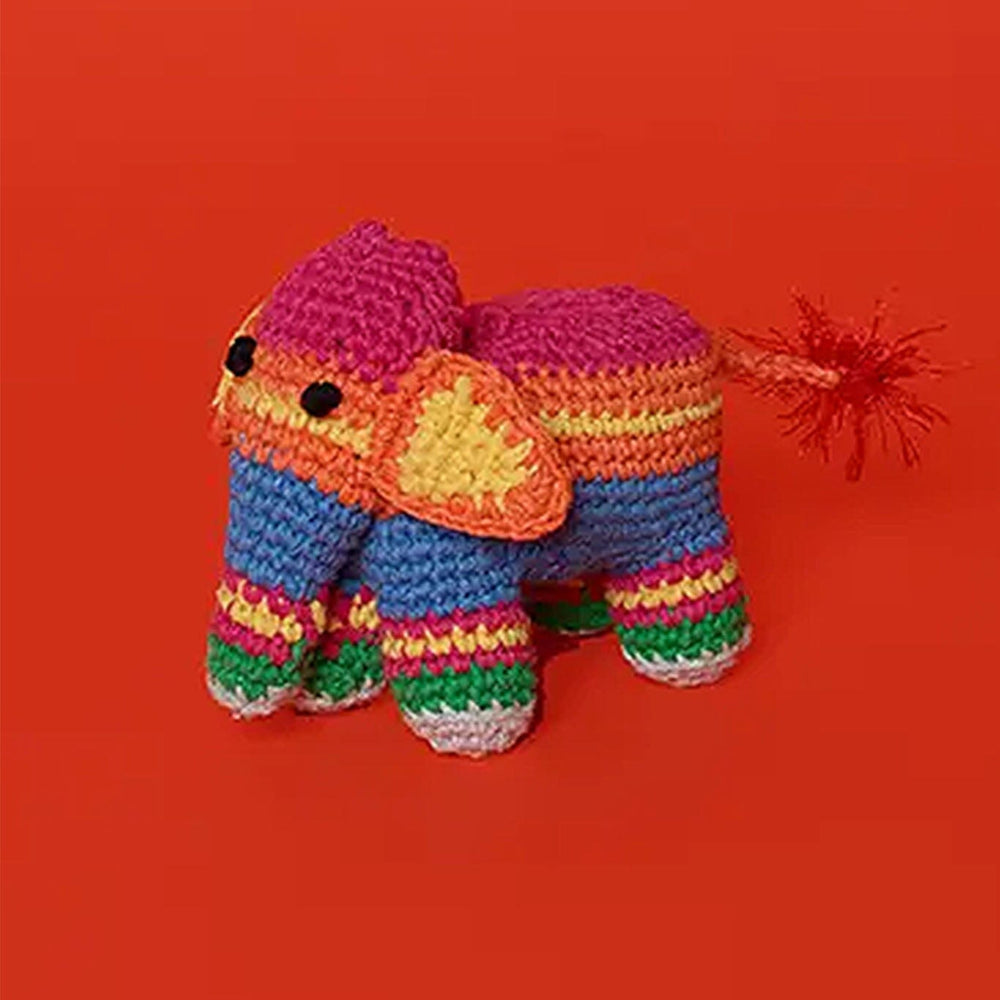 Colorful crocheted dog toy elephant on a red background