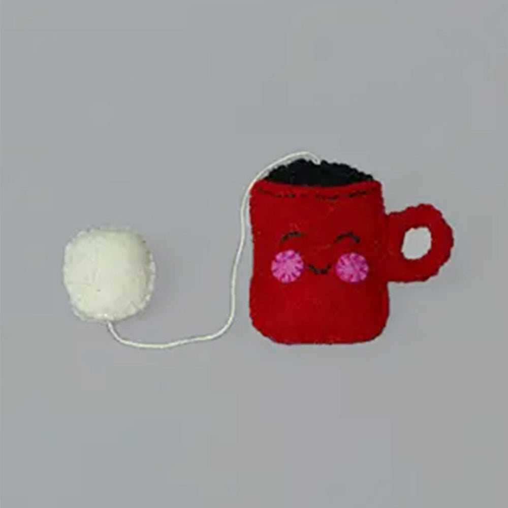 Red mug with a face and white yarn ball on a gray background