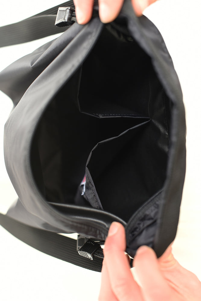 
                  
                    The inside pockets of a black waterproof crossbody bag from brand 8.6.4.
                  
                