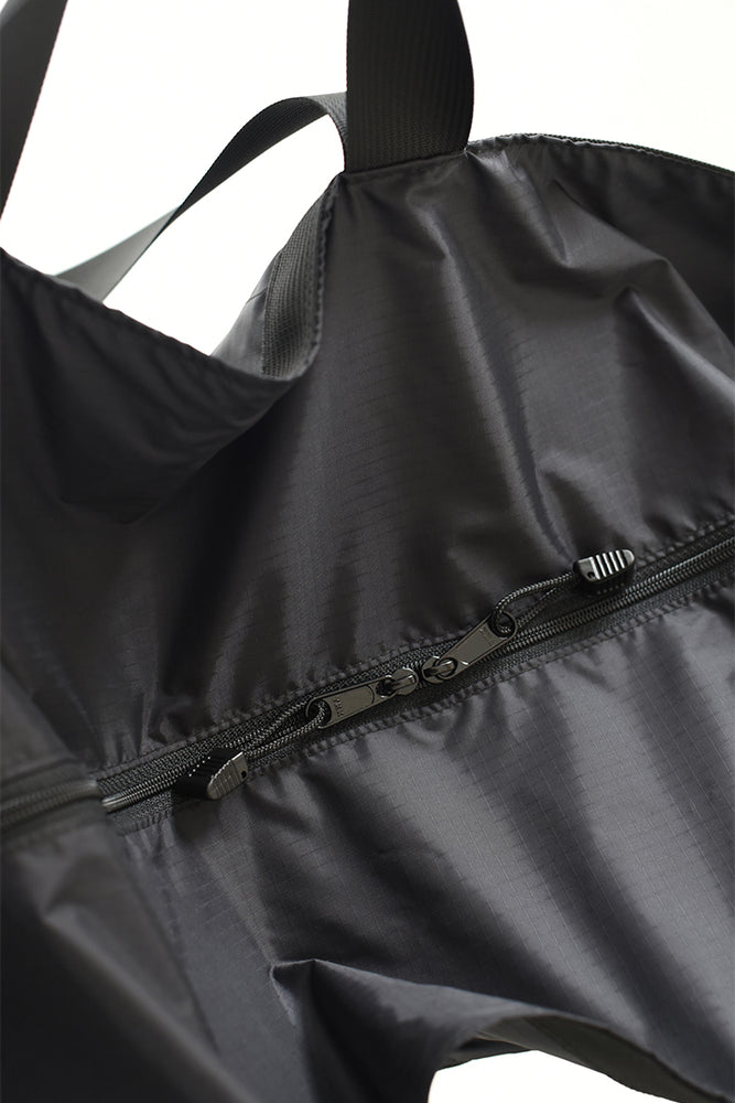 
                  
                    A detailed shot of the zippers on the 8.6.4. black nylon large duffle bag
                  
                
