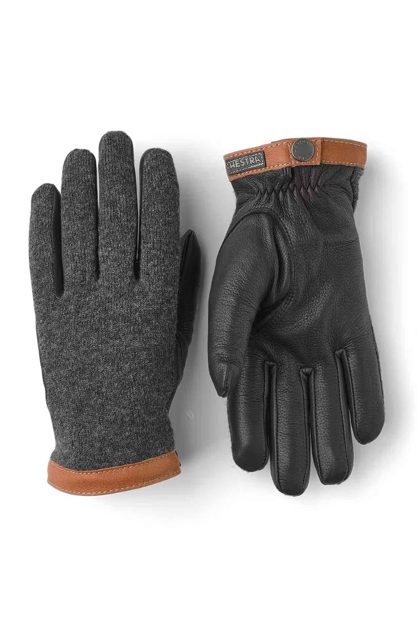 A pair of men's gloves with a charcoal wool jersey backhand and supple black deerskin palm, featuring a brown vegetable tanned goatskin cuff with a press stud.