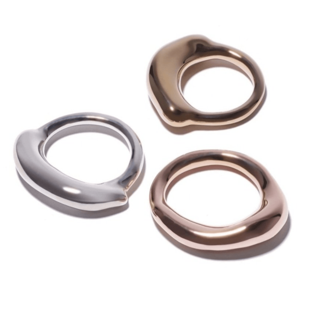 Silver, brass and rose gold rings with a thick organic top, viewed from the side, showing the thickness and the band's profile.