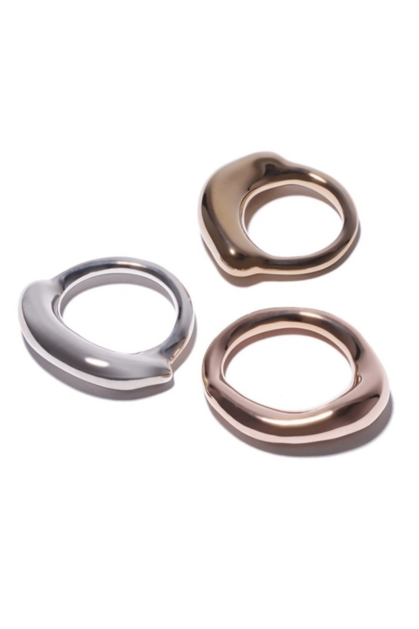 Silver, brass and rose gold rings with a thick organic top, viewed from the side, showing the thickness and the band's profile.