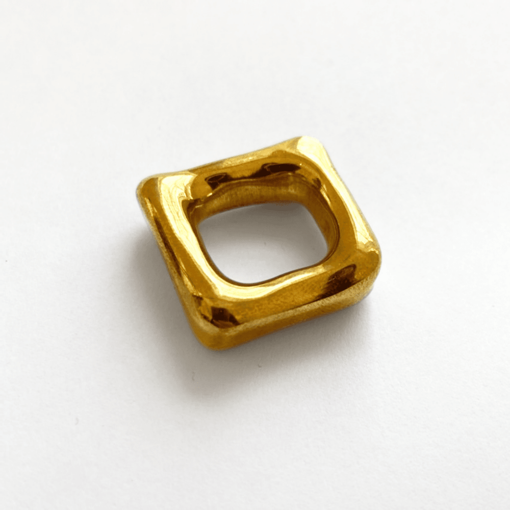 A solid heavy brass square band ring, handmade, with a glossy finish.
