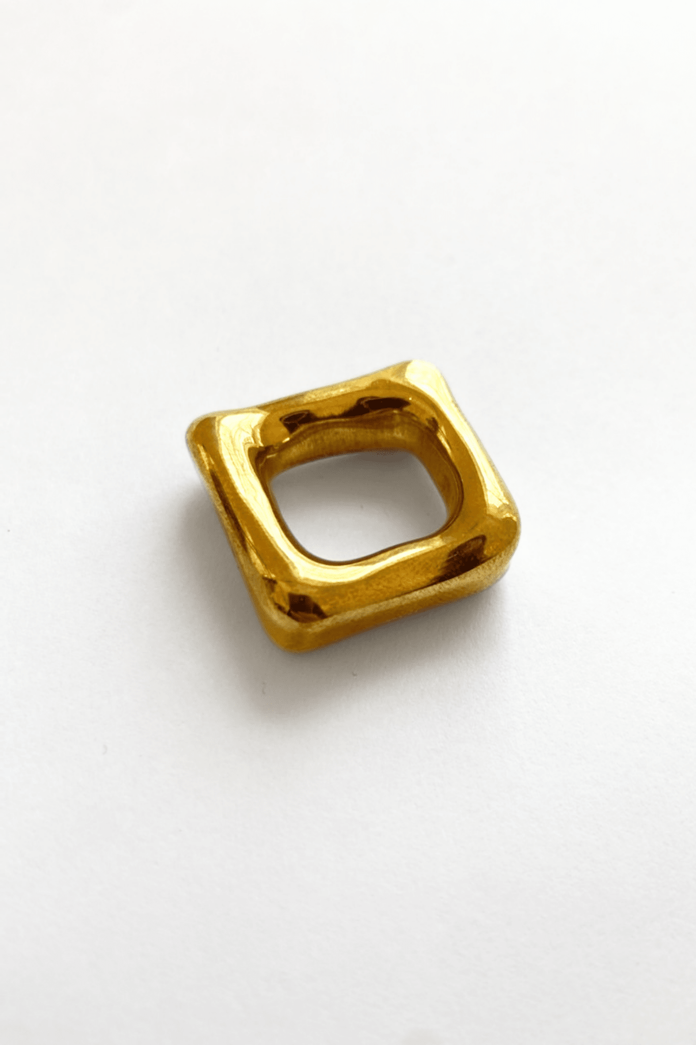 A solid heavy brass square band ring, handmade, with a glossy finish.