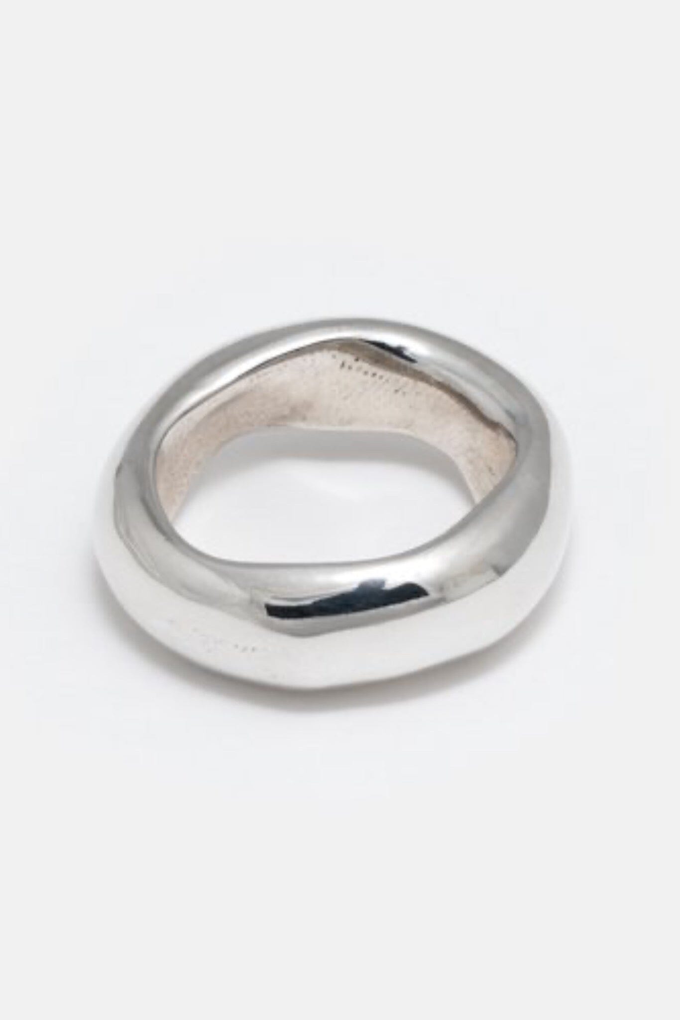 A thick silver band ring with a smooth, heavy metal organic design.
